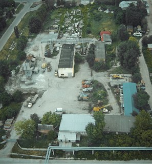 An aerial view of a large industrial site with drones inspecting.
