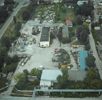 An aerial view of a large industrial site with drones inspecting.