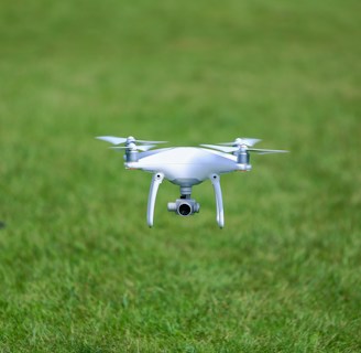 A drone flying over a lush green agricultural field.