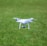 A drone flying over a lush green field during the day.