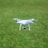 A drone flying over a lush green field during the day.