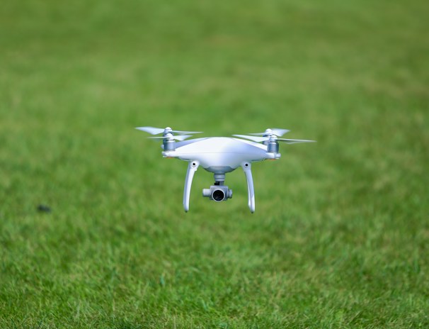 Aerial view of a drone flying over a green field.