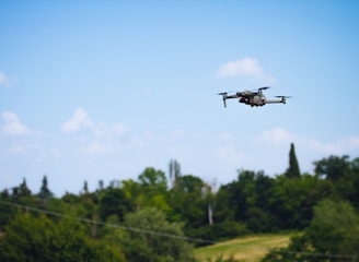 Aerial view of a drone flying over a green farm, capturing data.