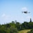 A drone flying over a lush green farm, capturing aerial views of crops.