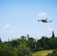 A drone flying over a lush green farm, capturing aerial views of crops.