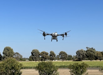A drone flying over a green agricultural field.