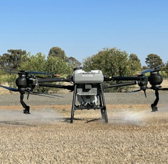 A close-up of a drone spraying crops in a farm.