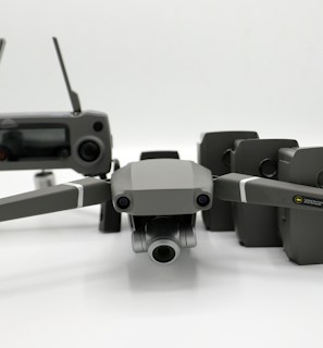 A group of drones lined up ready for deployment in a field.